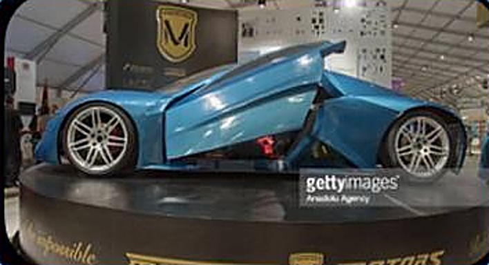 Coupé bleu aux portes ouvertes, exposé sur un podium