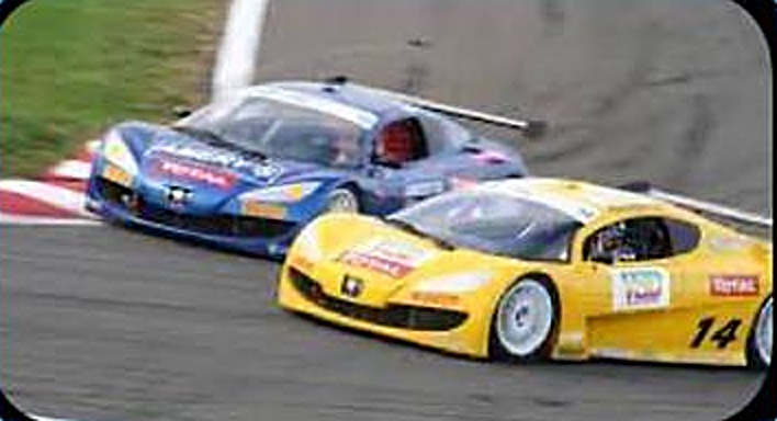 Deux Peugeot RC de course, l'une bleue, l'autre jaune, dans un virage