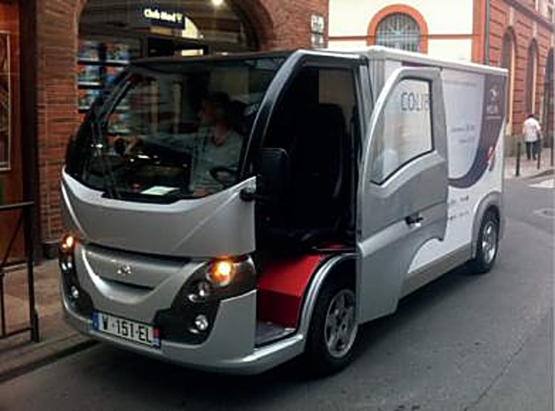Colibus gris à l’essai dans une rue, au volant un conducteur